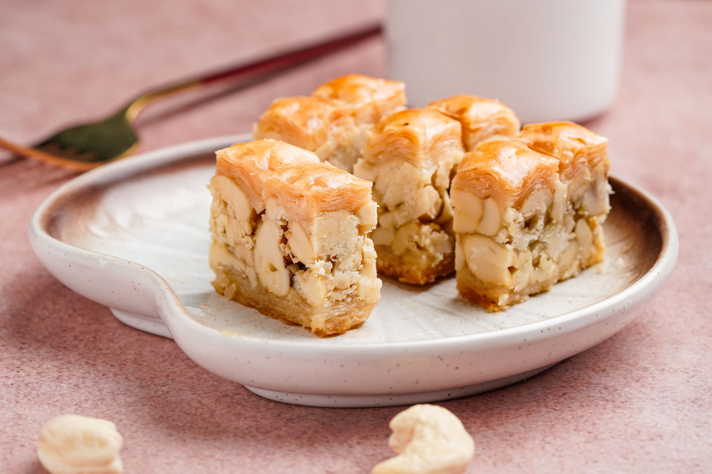 Stack of cashew baklava pieces on a white plate